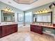 Bright bathroom featuring double vanities, a soaking tub, and a glass block window at 2805 Ponkan Meadow Dr, Apopka, FL 32712