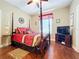 Bedroom with dark hardwood floors, canopy bed, ceiling fan, and window to let the light in at 2805 Ponkan Meadow Dr, Apopka, FL 32712