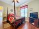 Bedroom with dark hardwood floors, canopy bed, ceiling fan, and window to let the light in at 2805 Ponkan Meadow Dr, Apopka, FL 32712
