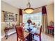 A dining room featuring a glass-topped table set for a meal, with large windows and elegant decor at 2805 Ponkan Meadow Dr, Apopka, FL 32712