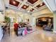 Elegant living room featuring coffered ceilings, tile flooring, and a decorative entertainment center at 2805 Ponkan Meadow Dr, Apopka, FL 32712