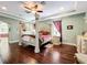 The main bedroom has hardwood floors, a ceiling fan, and a decorative four poster bed at 2805 Ponkan Meadow Dr, Apopka, FL 32712