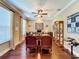 Home office boasts rich wood floors, elegant furniture, and a ceiling fan for added comfort at 2805 Ponkan Meadow Dr, Apopka, FL 32712