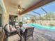 Covered patio features outdoor seating with a view of the screened pool and lush backyard at 2805 Ponkan Meadow Dr, Apopka, FL 32712