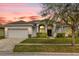 Charming one-story home with a manicured lawn, arched entryway, and two-car garage at 2819 Boating Blvd, Kissimmee, FL 34746