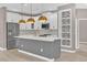 Modern kitchen featuring white cabinets, gray island, stainless steel appliances, and decorative backsplash at 2819 Boating Blvd, Kissimmee, FL 34746