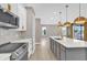Open kitchen with island, quartz countertops, stainless steel appliances, and wood-look floors at 2819 Boating Blvd, Kissimmee, FL 34746