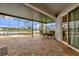 Screened-in lanai features brick pavers, a dining table, and views of the pool and pond at 2819 Boating Blvd, Kissimmee, FL 34746