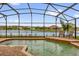 Screened-in pool with a serene pond view and lounging chairs at 2819 Boating Blvd, Kissimmee, FL 34746