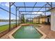 A screened-in pool with a brick border overlooks a tranquil pond at 2819 Boating Blvd, Kissimmee, FL 34746