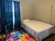 Bedroom with a bed, window with curtains, and a chair near an alphabet mat on the floor at 3651 N Goldenrod Rd # 210, Winter Park, FL 32792