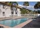 Community pool is surrounded by a fence, brick patio and mature landscaping at 3651 N Goldenrod Rd # 210, Winter Park, FL 32792