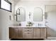 Elegant bathroom featuring double vanity with marble countertop and modern arched mirrors at 405 Calhoun Pl, Orlando, FL 32801