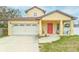 Inviting yellow two-story home featuring a bright red front door and attached one car garage at 410 South Hudson St, Orlando, FL 32835