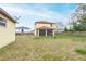 Spacious backyard showcasing the home's exterior and screened-in porch, offering outdoor living space at 410 South Hudson St, Orlando, FL 32835