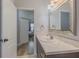Bathroom with a white sink, marble countertops, and framed mirror, leading into a bedroom at 410 South Hudson St, Orlando, FL 32835