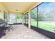 Screened-in back patio with brick flooring, view of the green backyard, and outdoor furniture at 410 South Hudson St, Orlando, FL 32835
