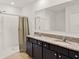 Well-lit bathroom with double granite vanity, framed mirror, and glass-enclosed shower at 432 Tallow Wood Cir, Debary, FL 32713