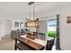 Bright dining area with a farmhouse table, modern lighting fixture, and sliding door access to the yard at 432 Tallow Wood Cir, Debary, FL 32713