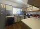 Functional kitchen featuring oak cabinets, laminate countertops, stainless steel sink, and modern appliances at 4419 S Semoran Blvd # 7, Orlando, FL 32822