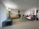 Spacious living room features plush carpeting, neutral paint, ample seating and a glass coffee table at 4419 S Semoran Blvd # 7, Orlando, FL 32822