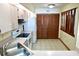 Functional kitchen featuring tiled floors, wooden cabinets, and essential appliances at 4516 Summergrove Ave, Orlando, FL 32812