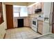 Bright kitchen featuring tiled flooring, stainless steel appliances, and wood-finish cabinetry at 4516 Summergrove Ave, Orlando, FL 32812