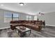 Spacious living room featuring a large leather sectional and modern flooring at 4521 Jim Glenn Dr, Orlando, FL 32808