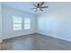 Comfortable bedroom features wood-look flooring, a ceiling fan, and a window at 455 Eaglecrest Dr, Haines City, FL 33844