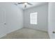 A comfortable bedroom with neutral carpet, a ceiling fan, and a window offering plenty of natural light at 455 Eaglecrest Dr, Haines City, FL 33844