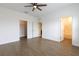 Bright main bedroom featuring wood-look floors, ceiling fan, and ensuite bathroom and closet access at 455 Eaglecrest Dr, Haines City, FL 33844