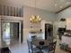 Well-lit dining area with modern chandelier, white cabinets, and stainless steel appliances, adjacent to the kitchen at 5323 Alcom Dr, Orlando, FL 32812