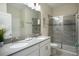 Bathroom featuring double sinks, granite countertops, a tiled shower, and modern fixtures at 561 Pebble Beach Dr, Davenport, FL 33896