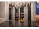 Arcade games with neon signs under a chandelier, featuring a textured wall design and a glossy tiled floor at 561 Pebble Beach Dr, Davenport, FL 33896