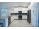 Contemporary white kitchen featuring stainless steel appliances, an island, and tile flooring at 561 Pebble Beach Dr, Davenport, FL 33896