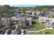 Aerial view of the property with a parking lot and pond surrounded by lush green trees at 5842 Peregrine Ave # C01, Orlando, FL 32819