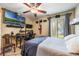 Bedroom with a large television, desk setup, and neutral colors at 5842 Peregrine Ave # C01, Orlando, FL 32819