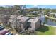 Exterior view of the condo unit with a parking lot and pond surrounded by lush green trees at 5842 Peregrine Ave # C01, Orlando, FL 32819