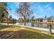 Scenic community view of the pond and sidewalk lined with several condo units at 5842 Peregrine Ave # C01, Orlando, FL 32819