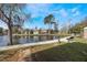 Scenic community view of the pond and sidewalk lined with several condo units and mature trees at 5842 Peregrine Ave # C01, Orlando, FL 32819