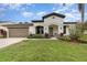 Charming single-story home with a well-maintained lawn, two-car garage and inviting front porch at 624 Woods Landing Dr, Minneola, FL 34715