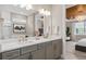 Contemporary bathroom featuring double vanity sinks, wood-look floor tiles, and an art piece at 6319 Dew Drop Loop, St Cloud, FL 34771