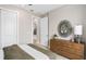 Stylish bedroom with a modern mirror and a view into the hallway, with a wooden dresser for storage at 6319 Dew Drop Loop, St Cloud, FL 34771