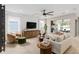 Bright living room featuring a modern ceiling fan, wooden console, and comfortable seating area at 6319 Dew Drop Loop, St Cloud, FL 34771