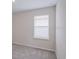 Carpeted bedroom with a neutral color scheme and window with privacy blinds at 6634 Lullaby Way, Mascotte, FL 34753