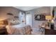 Bedroom with neutral colored walls has a bed, a nightstand, a window, and a softball-themed picture at 6634 Lullaby Way, Mascotte, FL 34753