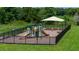 Community playground featuring slides and climbing structures, fully enclosed with black metal fencing at 6634 Lullaby Way, Mascotte, FL 34753