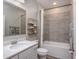 This bathroom features a shower and tub combo, gray walls, and a single sink vanity at 6634 Rhythm Dr, Mascotte, FL 34753