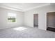 A carpeted bedroom features a window with a pond view, a tray ceiling, and two closets at 6634 Rhythm Dr, Mascotte, FL 34753