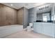 This bathroom features a combination shower-tub, blue vanity, and neutral tile flooring at 101 S Eola Dr # 1001, Orlando, FL 32801